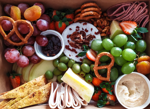 Platter of meat, cheese, fruits, and pretzels