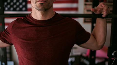 Man holding onto workout bar resting after workout