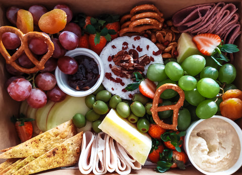 Platter of meat, cheese, fruits, and pretzels