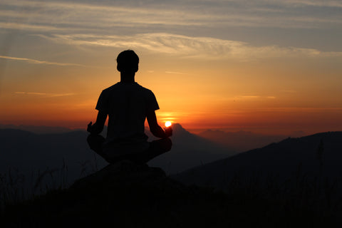Man meditating during the sunset