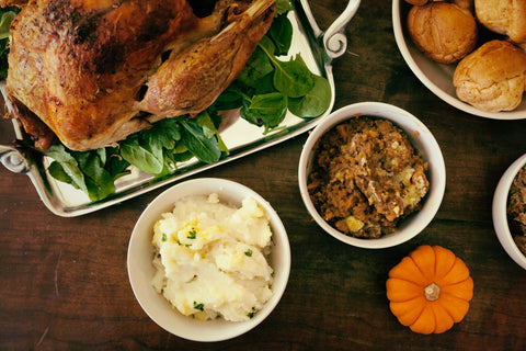 Holiday dinner table with turkey, mashed potatoes, and stuffing